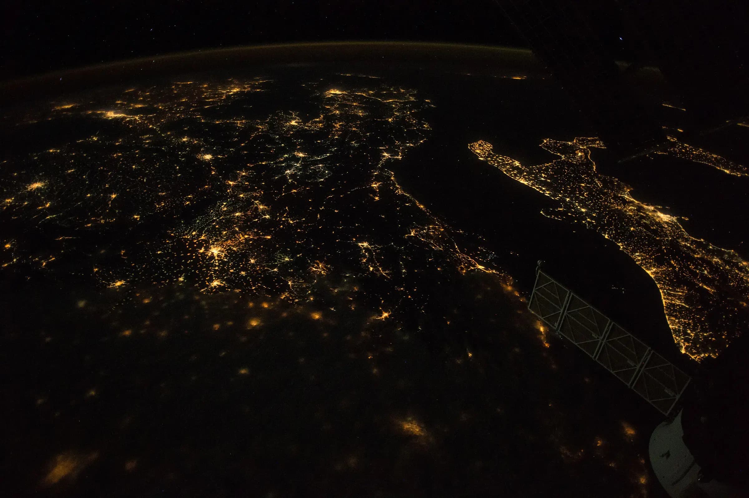 Southern Europe at night from orbit — towns and cities strung across the continent and down Italy.